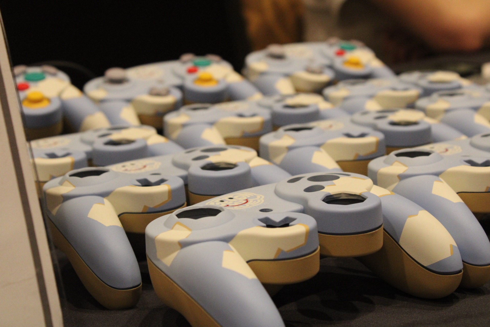 A table of customized controllers featuring Get On My Level 2022. The controllers are a light blue color with blocky white clouds for the design. At the top of each controller is the Get On My Level 2022 logo. The logo looks like a light-blue cloud with two eyes and a smile. It contains text is a white font color that reads "Get On My Level."